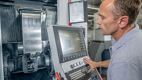 Mitarbeiter bei der Programmierung einer CNC-Fräsmaschine